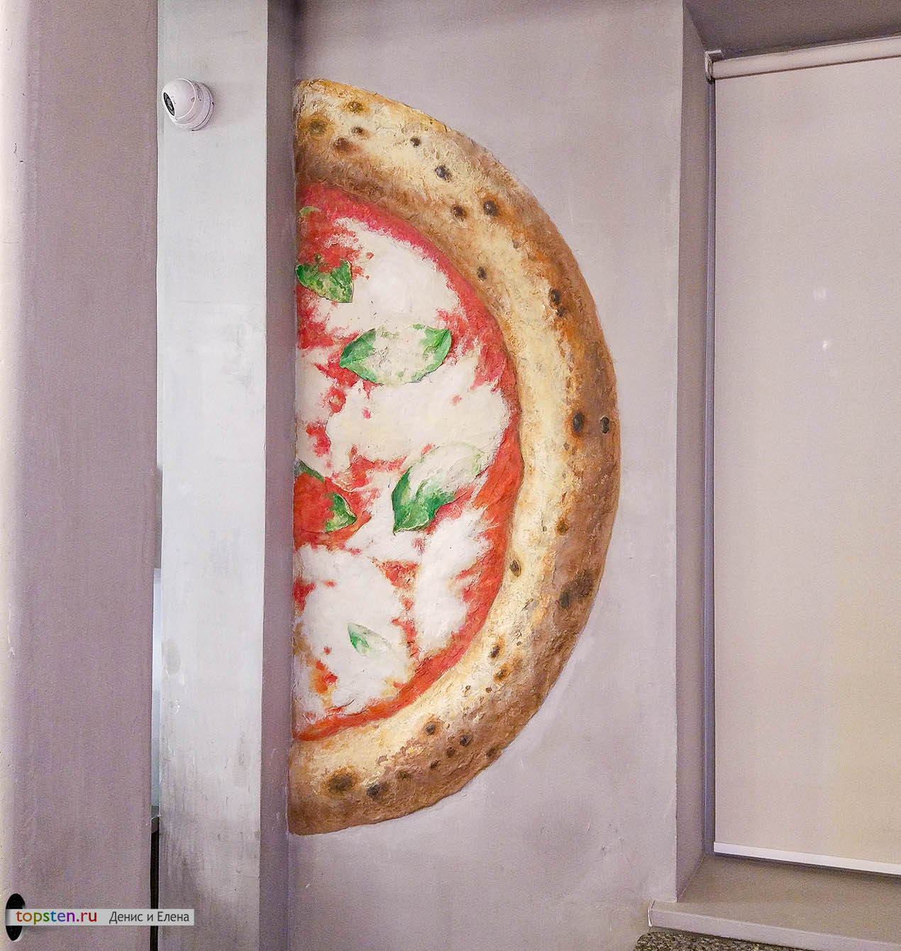 объемная большая пицца на стене кафе сделана в виде барельефа из гипса и расписана акриловыми красками